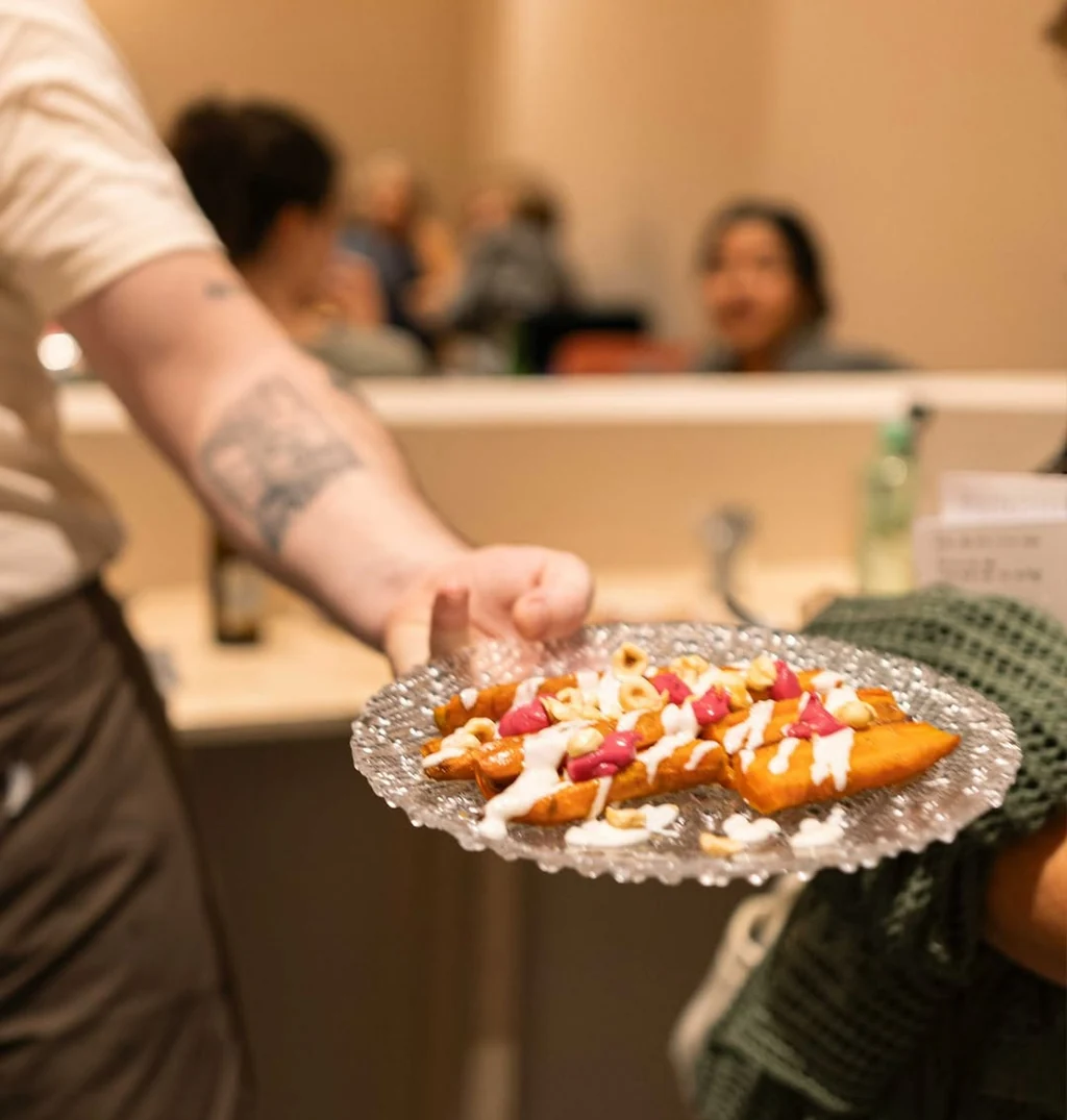Un plato para compartir servido entre el público de Bar Babel